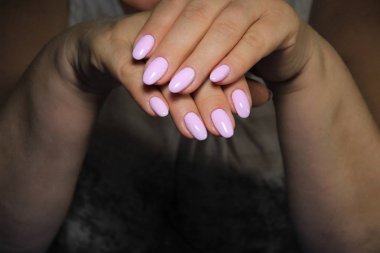 İnanılmaz doğal tırnaklar. Temiz manikürlü kadın elleri. Jel cilası uygulandı.