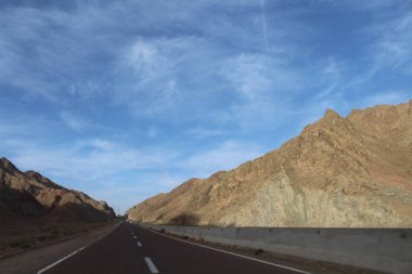 Mavi gökyüzü ve güzel dağ manzarası olan yol