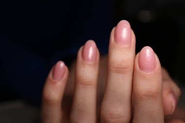 İnanılmaz doğal tırnaklar. Temiz manikürlü kadın elleri. Jel cilası uygulandı.
