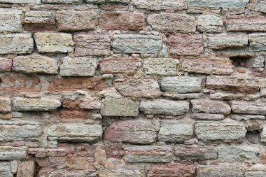 Yaşlı ve yıpranmış kırmızı tuğlanın ayrıntılı yakın görünümü