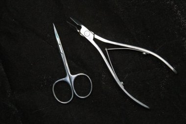 Siyah arka plan üzerinde düzenlenmiş çeşitli zarif manikür araçları.