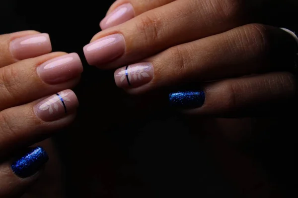 Closeup of hands of a young woman manicure on nails against white background — Stock Photo, Image