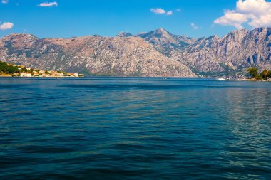 İnanılmaz parlak deniz manzarası. Yeşil ormanlık dağlar ve mavi deniz, mavi gökyüzü ve beyaz bulutlar görünümünü. Boka Kotorska Bay, Karadağ