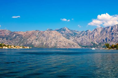 İnanılmaz parlak deniz manzarası. Yeşil ormanlık dağlar ve mavi deniz, mavi gökyüzü ve beyaz bulutlar görünümünü. Boka Kotorska Bay, Karadağ