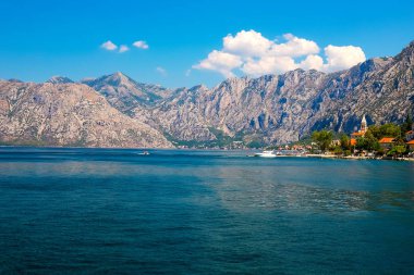 İnanılmaz parlak deniz manzarası. Yeşil ormanlık dağlar ve mavi deniz, mavi gökyüzü ve beyaz bulutlar görünümünü. Boka Kotorska Bay, Karadağ