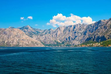 İnanılmaz parlak deniz manzarası. Yeşil ormanlık dağlar ve mavi deniz, mavi gökyüzü ve beyaz bulutlar görünümünü. Boka Kotorska Bay, Karadağ