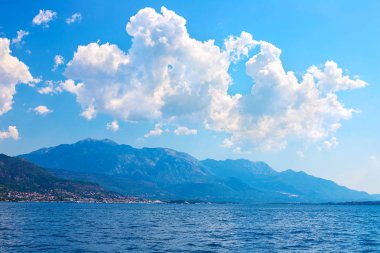 İnanılmaz parlak deniz manzarası. Yeşil ormanlık dağlar ve mavi deniz, mavi gökyüzü ve beyaz bulutlar görünümünü. Boka Kotorska Bay, Karadağ