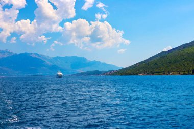 İnanılmaz parlak deniz manzarası. Yeşil ormanlık dağlar ve mavi deniz, mavi gökyüzü ve beyaz bulutlar görünümünü. Boka Kotorska Bay, Karadağ