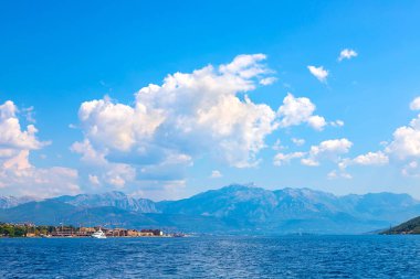 İnanılmaz parlak deniz manzarası. Yeşil ormanlık dağlar ve mavi deniz, mavi gökyüzü ve beyaz bulutlar görünümünü. Boka Kotorska Bay, Karadağ