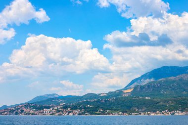 İnanılmaz parlak deniz manzarası. Yeşil ormanlık dağlar ve mavi deniz, mavi gökyüzü ve beyaz bulutlar görünümünü. Boka Kotorska Bay, Karadağ