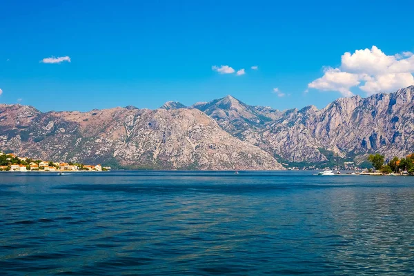 İnanılmaz parlak deniz manzarası. Yeşil ormanlık dağlar ve mavi deniz, mavi gökyüzü ve beyaz bulutlar görünümünü. Boka Kotorska Bay, Karadağ