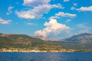 İnanılmaz parlak deniz manzarası. Yeşil ormanlık dağlar ve mavi deniz, mavi gökyüzü ve beyaz bulutlar görünümünü. Boka Kotorska Bay, Karadağ