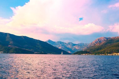 İnanılmaz parlak deniz manzarası. Yeşil ormanlık dağlar ve mavi deniz, mavi gökyüzü ve beyaz bulutlar görünümünü. Boka Kotorska Bay, Karadağ