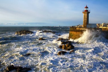 Deniz manzarası. Dalgalar deniz fenerini günbatımında taşlara karşı Atlantik Okyanusu kaza. Lisbon, Portekiz