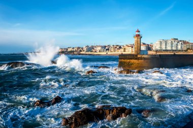 Deniz manzarası. Dalgalar deniz fenerini günbatımında taşlara karşı Atlantik Okyanusu kaza. Lisbon, Portekiz