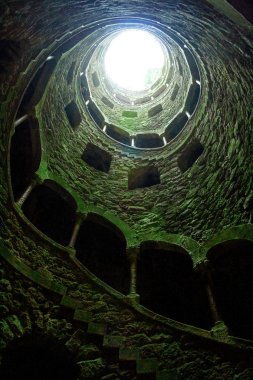 İçinde pencereler ve merdivenler olan bir kulenin güzel bir görüntüsü. Quinta da Regaleira kalesi, Monteiro Sarayı, Sintra, Portekiz