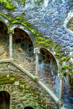 İçinde pencereler ve merdivenler olan bir kulenin güzel bir görüntüsü. Quinta da Regaleira kalesi, Monteiro Sarayı, Sintra, Portekiz