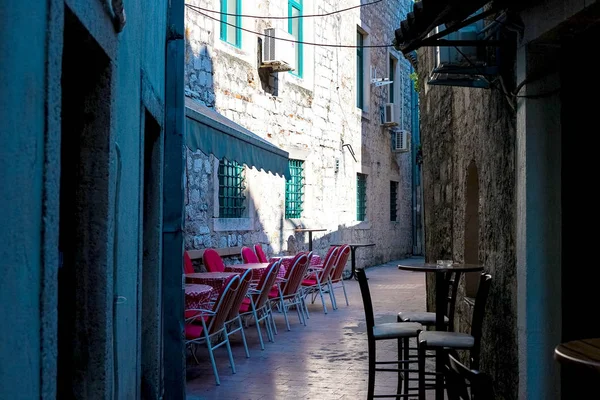 Street cafe on a narrow street in the old town of Kotor, Montenegro, August 2018