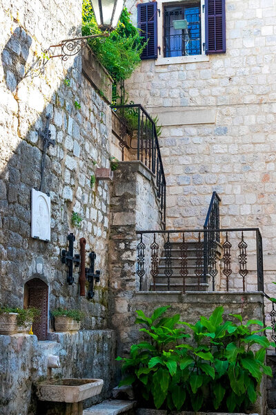 The facade of the building of the authentic old town of Kotor, Montenegro. We see old stone houses and an old staircase