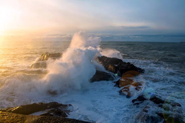 Golven van de Atlantische Oceaan crashen tegen een rots bij zonsondergang. — Stockfoto