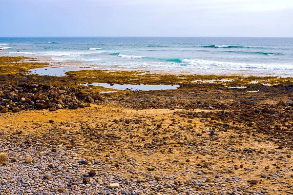 Pequenas pedras na praia preta — Fotografia de Stock