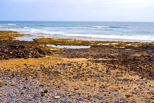 Pequenas pedras na praia preta — Fotografia de Stock