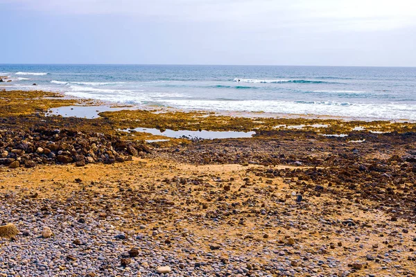 Pequenas pedras na praia preta — Fotografia de Stock