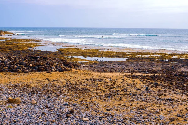 Pequenas pedras na praia preta — Fotografia de Stock