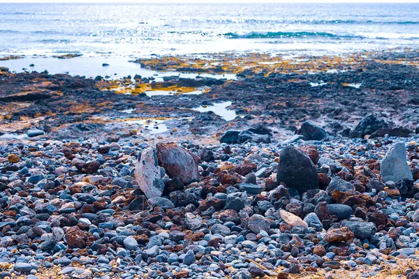 Pequenas pedras na praia preta — Fotografia de Stock