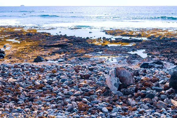 Pequenas pedras na praia preta — Fotografia de Stock