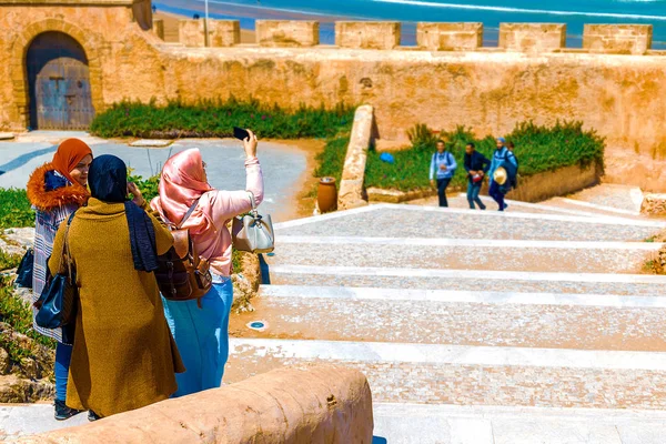 Τρεις αραβικές κοπέλες περνούν χρόνο μαζί στον καθαρό αέρα και παίρνουν φωτογραφίες στον ωκεανό. Ραμπάτ, Μαρόκο — Φωτογραφία Αρχείου