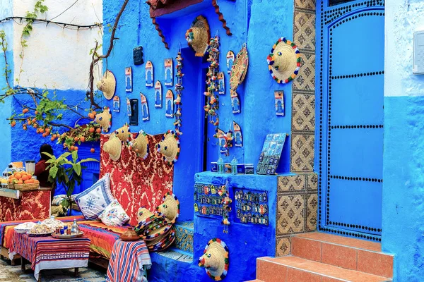 Barevné marocké tkaniny a ručně vyráběné suvenýry na ulici v modrém městě Chefchaouen, Maroko, Afrika.. — Stock fotografie