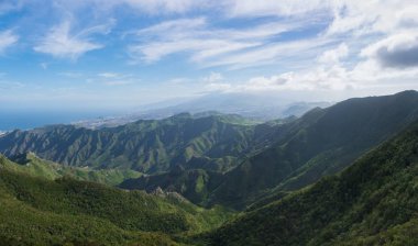 Anaga Dağları'nın güzel panoramik manzarası. Yeşil tepeler, renkli gökyüzü ve derin mavi okyanus. Tenerife, Kanarya Adaları.