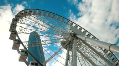 HONG KONG - Dönme dolap mavi gökyüzüne karşı arka planda gökdelen.