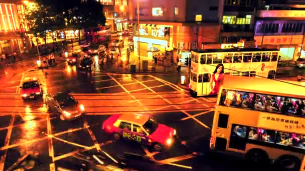 HONG KONG - Rainy night street view time lapse med människor, dubbeldäckare spårvagnar och trafik passerar. Lutningsskifte med 4K-upplösning. — Stockvideo