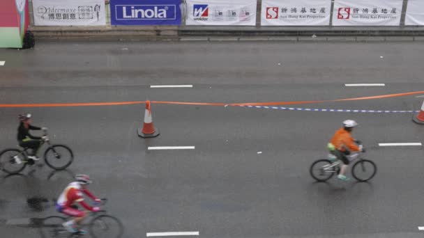 HONG KONG - Ciclista depois de cruzar a linha de chegada de Hong Kong Cyclothon. Resolução 4K. Perfil plano sem correção de cor. Visite meu portfólio para a versão graduada a cores . — Vídeo de Stock