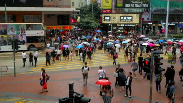 Hong KONG - Şemsiyeli insanlar yağmurlu günlerde şehir merkezinde karşıdan karşıya geçiyorlar. 4K çözünürlüğü — Stok video