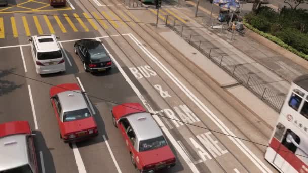 HONG KONG - Stadscentrum uitzicht op de straat met dubbeldekker trams en verkeer. 4K resolutie. Vlakke profiel zonder kleurcorrectie. Bezoek mijn portfolio voor kleur graded versie. — Stockvideo