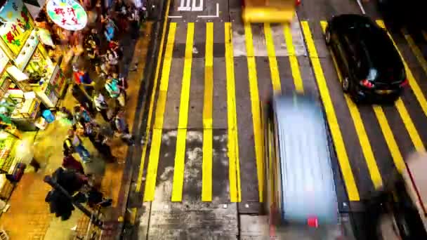 HONG KONG - Människor korsar gatan på kvällen. 4K upplösningstid förfaller. — Stockvideo