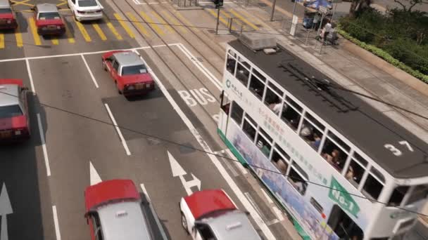 HONG KONG - City centre street view with double decker trams and traffic. Разрешение 4К. Плоский профиль без цветовой коррекции. Висит мое портфолио для цветной версии . — стоковое видео