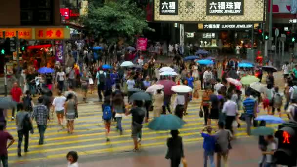 HONG KONG -雨の日に通りを横断する二重デッキトラムと傘を持つ人々と都市交通。スピードアップ. — ストック動画