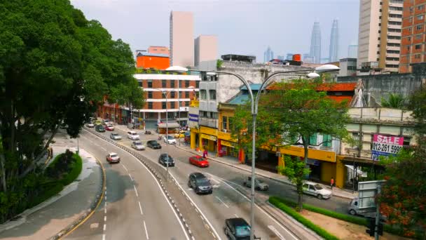 KUALA LUMPUR - tráfego Kuala Lumpur em Chow Kit com torres gêmeas Petronas em segundo plano. Acelera. Resolução 4K . — Vídeo de Stock