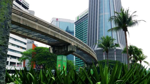 KUALA LUMPUR - Vista do parque com Monorail passando e edifícios altos no fundo. Resolução 4K — Vídeo de Stock