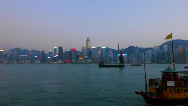 HONG KONG - Victoria Harbour kvällsutsikt med båtar och skyskrapor i bakgrunden. — Stockvideo