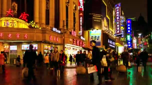 Shanghai - Nanjing Road with people and colorful signboards glowing at rainy night. 4K resolution time lapse panning. — Stock Video