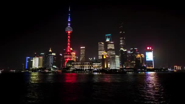 Shanghai - Vista nocturna de la ciudad con rascacielos, Oriental Pearl Tower y río con barcos. Resolución 4K time lapse zoom in . — Vídeos de Stock