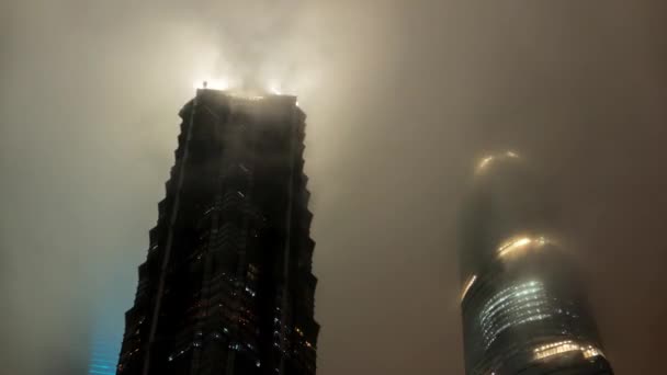 Xangai - Novembro de 2015: Vista noturna de arranha-céus escondidos em nuvens em Lujiazui, Pudong. zoom de lapso de tempo de resolução 4K. — Vídeo de Stock