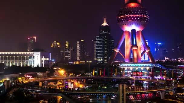 Shanghai - Vista nocturna del tráfico rotonda con la gente en el skywalk por la brillante Oriental Pearl Tower. Caducidad de la resolución 4K. — Vídeos de Stock