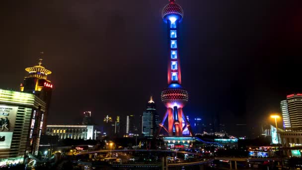 Shanghai - Nachtzicht op rotonde verkeer met mensen op skywalk door gloeiende Oriental Pearl Tower. 4K-resolutieverjaring — Stockvideo