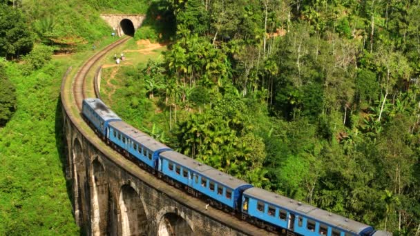 Ella - Vista aérea del tren en el viejo puente del arco en la exuberante campiña montañosa. Sri Lanka. Resolución 4K. — Vídeos de Stock